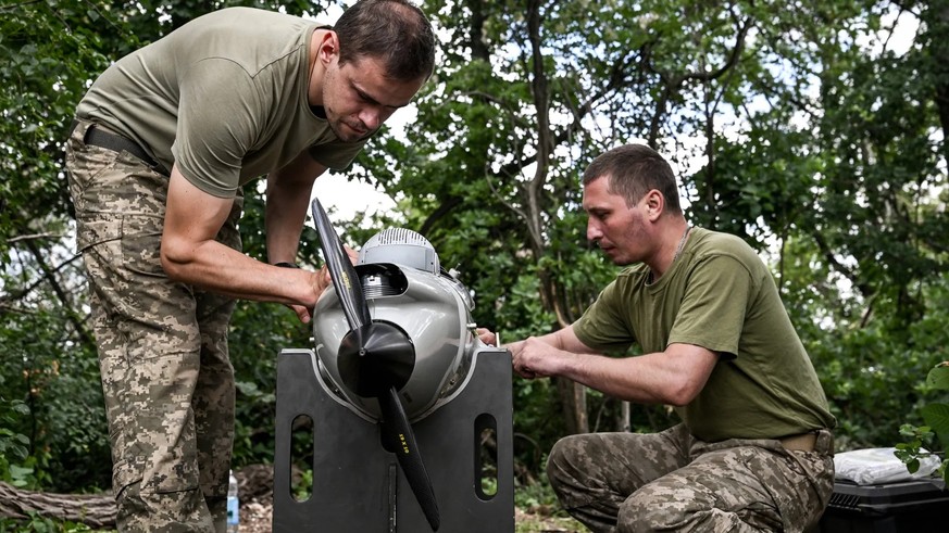 Des soldats ukrainiens assemblent un drone de reconnaissance en vue de leur mission.