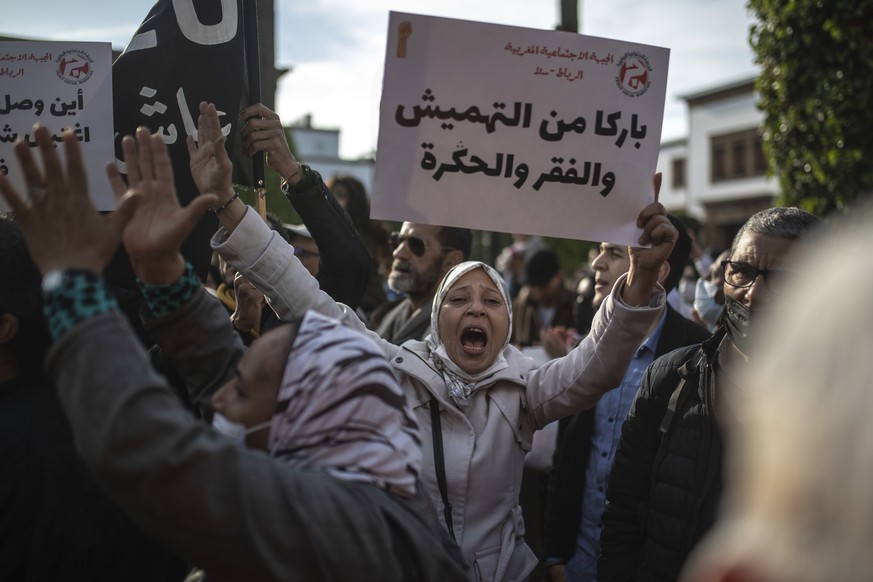 A woman chants slogans and holds a banner as people protest against price hikes and commemorate the anniversary of the 2011 Arab Spring protests, in Rabat, Morocco, Feb 20, 2022. Banner in Arabic read ...