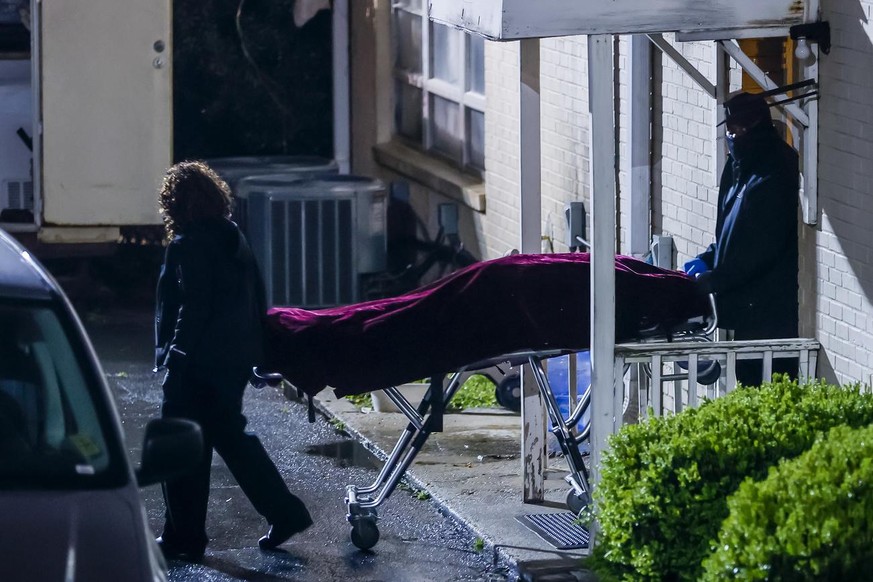 epa09079059 Officials with the Fulton County Medical Examiner&#039;s office remove a body from the Gold Spa massage parlor after a shooting on Piedmont Road in Atlanta, Georgia, USA, 16 March 2021. At ...