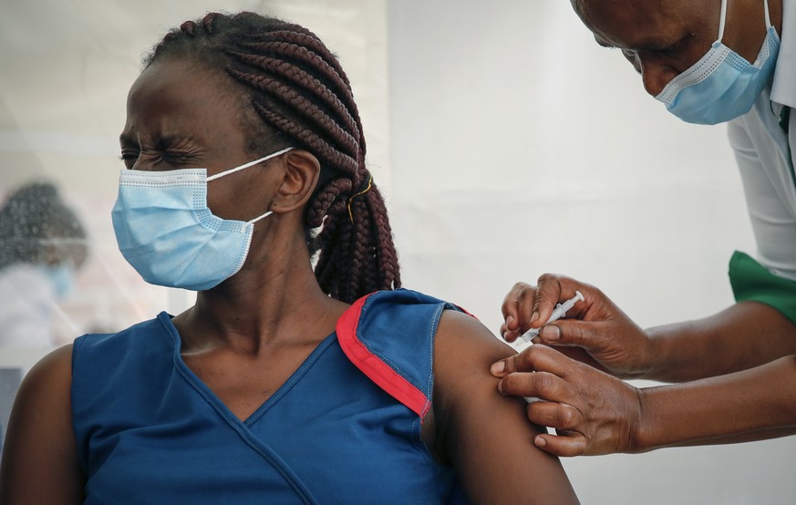 A frontline worker reacrs as she receives a shot of AstraZeneca COVID-19 vaccine, manufactured by the Serum Institute of India and provided through the global COVAX initiative, in Machakos, Kenya, Wed ...