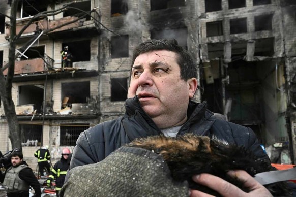 Un homme serre dans ses bras son chat, mort dans «le» bombardement de son immeuble, dans le quartier Obolon, à Kiev, le 14 mars 2022.