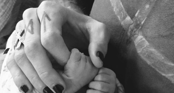 Machine Gun Kelly qui tient la main de sa fille.