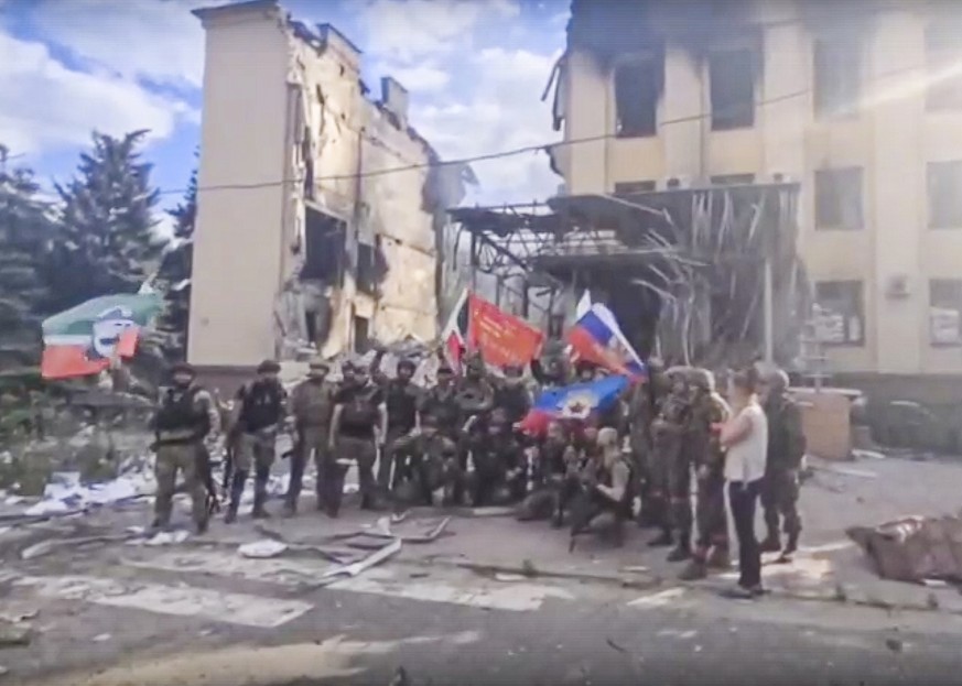 FILE - This photo taken from video provided by Ramzan Kadyrov&#039;s Official Telegram channel released on Saturday, July 2, 2022, shows Russian troops including soldiers of Chechen regiment waving Ru ...