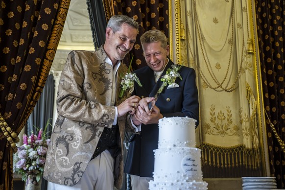 Xavier, gauche et Daniel, droite coupent le gateau apres leur ceremonie de mariage, a la Maire de la Ville de Geneve, le premier couple du meme sexe a se marier, celebrent la transformation du partena ...