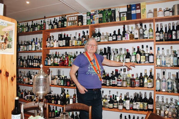 Diane Tripet devant la collection d'absinthes, dans le Val-de-Travers.