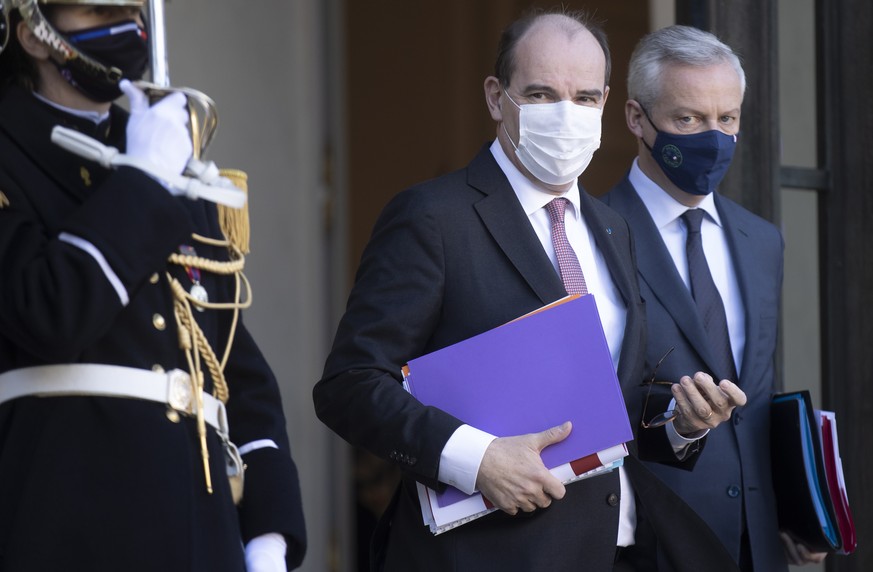 epa09667749 French Prime Minister Jean Castex (C) flanked by Finance Minister Bruno Le Maire (R) leave the Elysee Palace after attending the first weekly cabinet meeting of the year, in Paris, France, ...