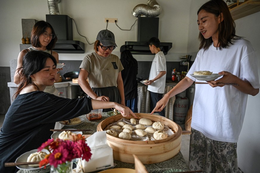 The photo taken on July 14, 2025 shows Chen Yani (R), also known as &quot;Keke&quot; eating lunch with friends and guests in a female co-living space called &quot;Keke�s Imaginative Space&quot; in Han ...