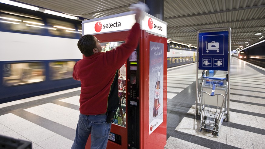 An employee of Selecta cleans a Selecta snack vending machine in the underground part of the main train station in Zurich, Switzerland, pictured on January 20, 2009. (KEYSTONE/Gaetan Bally)

Ein Mitar ...
