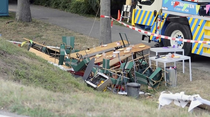 In this frame grab taken from video, tables and chairs turned over are seen at the site where a truck plowed into a gathering in the village of Nieuw-Beijerland, Netherlands, Saturday Aug. 27, 2022. A ...