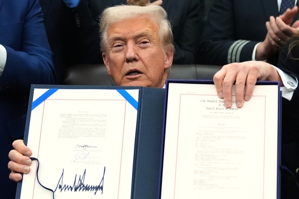 President Donald Trump displays the signed the funding bill to reopen the government, in the Oval Office of the White House, Wednesday, Nov. 12, 2025, in Washington. (AP Photo/Jacquelyn Martin)
Donald ...