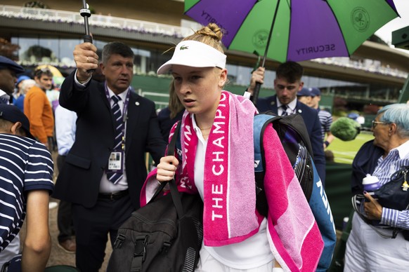 Celine Naef of Switzerland leaves the court while the play is suspended due to rain during her first round match against Anastasia Potapova of Russia at the All England Lawn Tennis Championships in Wi ...