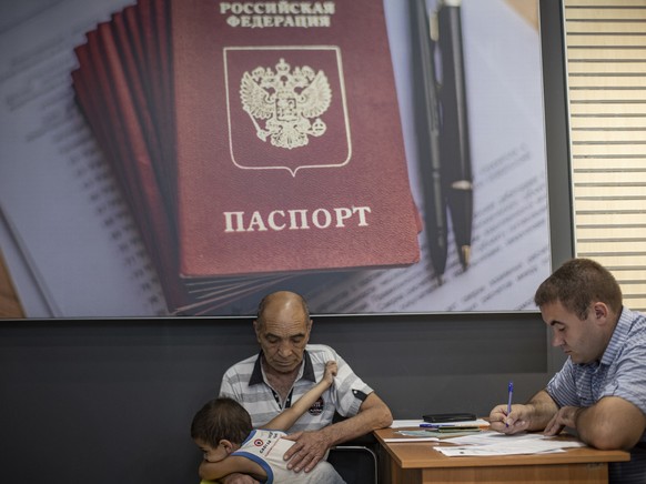 epaselect epa10116787 A picture taken during a visit to Berdyansk organised by the Russian military shows residents submitting documents at a center for the preparation of documents for the registrati ...