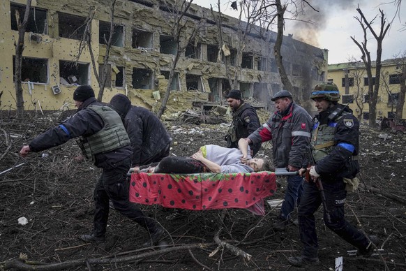 Ukrainian emergency employees and volunteers carry an injured pregnant woman from a maternity hospital damaged by shelling in Mariupol, Ukraine, Wednesday, March 9, 2022. The baby was born dead. Half  ...