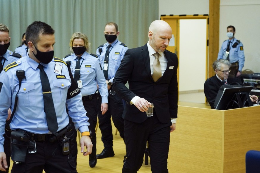 Le tueur norvégien Anders Behring Breivik est escorté par la police alors qu&#039;il marche à l&#039;intérieur d&#039;une salle d&#039;audience improvisée au premier jour d&#039;une audience où il dem ...