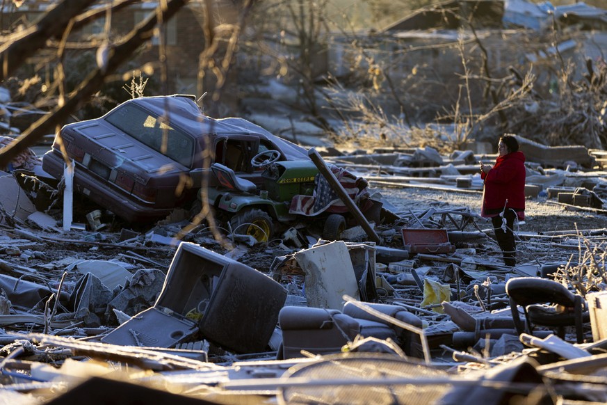 Dena Ausdorn stands at the remains of her home after a tornado in Dawson Springs, Ky., Sunday, Dec. 12, 2021. Ausdorn has lived there for 28 years and lost two of her dogs with another left paralyzed  ...