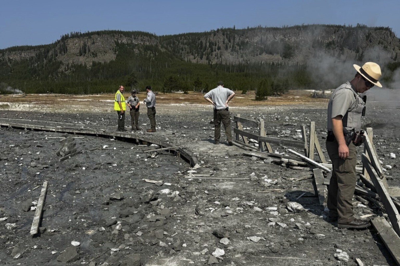 In this photo released by the National Park Service, park staff assess the damage to Biscuit Basin boardwalks after a hydrothermal explosion at Biscuit Basin in Yellowstone National Park, Wyo., Tuesda ...