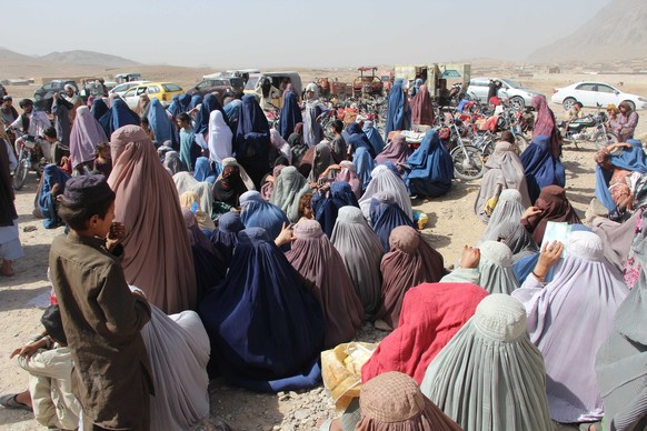 epa10793133 Afghans wait to receive rations distributed by the (UMMAH) Welfare Trust, a UK-based international relief and development charity established in Kandahar, Afghanistan, 10 August 2023. Rati ...