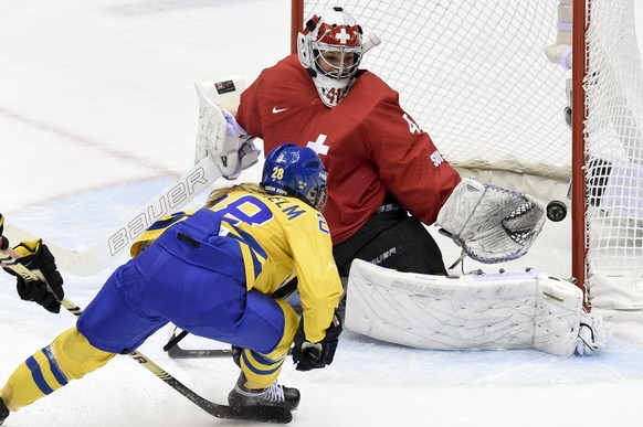 Sweden&#039;s forward Michelle Lowenhielm, left, scores the first goal against Switzerland&#039;s goalkeeper Florence Schelling, right, during the women&#039;s ice hockey bronze medal game between Swi ...