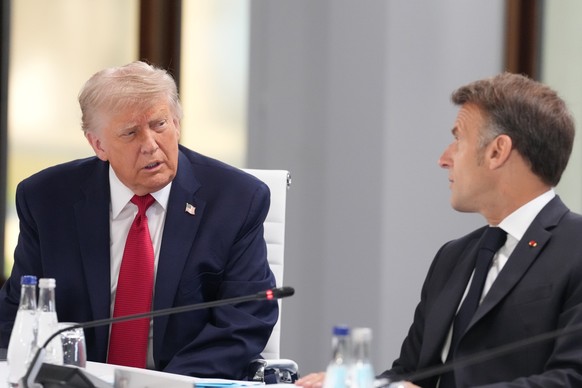 U.S. President Donald Trump, left, speaks with French President Emmanuel Macron during a working session at the G7 summit in Evian-les-Bains, France, Wednesday, June 17, 2026. (AP Photo/Thibault Camus ...