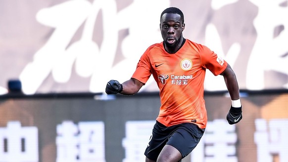 Dutch-born Ghanaian football player Elvis Manu of Beijing Renhe F.C., right, keeps the ball during the 30th round match of Chinese Football Association Super League CSL against Dalian Yifang in Dalian ...