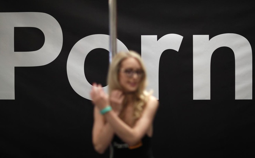 Porn actress Ginger Banks stands in the Pornhub booth during the AVN Adult Entertainment Expo, Wednesday, Jan. 24, 2018, in Las Vegas. (AP Photo/John Locher)