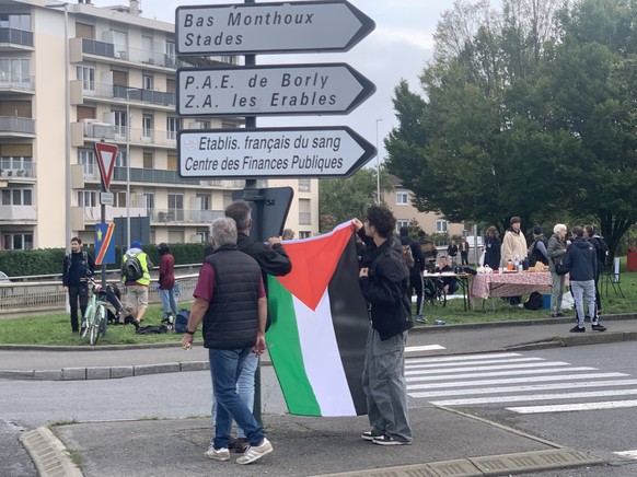 Accrochage d'un drapeau palestinien au rond-point du Burger King d'Annemasse.