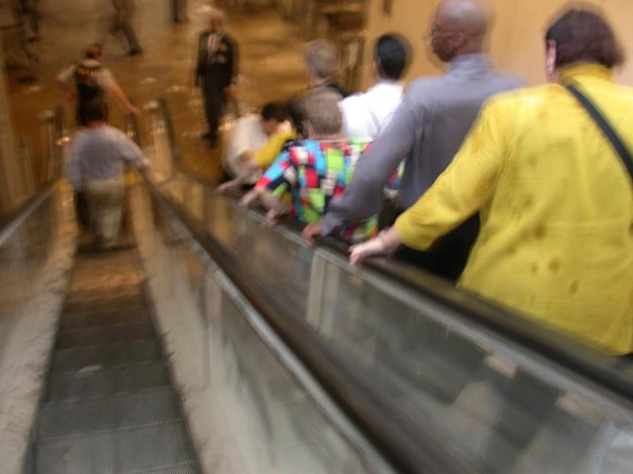 Des personnes évacuées prennent un escalator pour descendre dans la tour 1