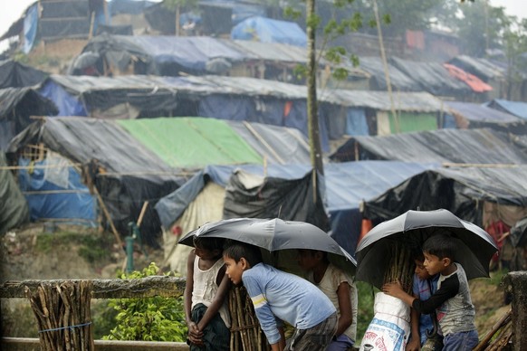 epa06242055 Rohingya refugees stand under the rain waiting for relief near a camp at Tengkhal, Ukhiya, Coxsbazar, Bangladesh, 03 October 2017. According to UNHCR, more than 500 thousand Rohingya refug ...