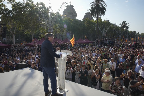 Catalan independence leader and former President Carles Puigdemont addresses supporters after his arrival near the Catalan parliament to attend the investiture debate in Barcelona, Spain, Thursday Aug ...