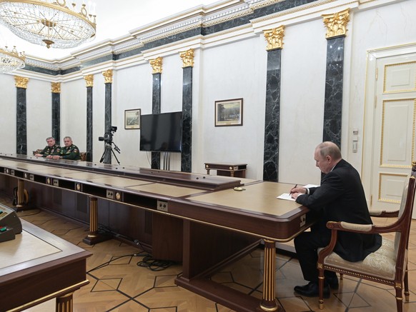 epa09789483 Russian President Vladimir Putin (R) attends a meeting with Russian Defence Minister Sergei Shoigu (C) and Russian General Staff ?hief Valery Gerasimov (L) in Moscow, Russia, 27 February 2 ...