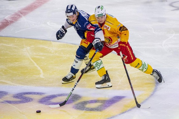 Dario Simion, links, von Zug im Spiel gegen Stefan Ruegsegger, rechts, von Langnau beim Eishockey Meisterschaftsspiel in der Qualifikation der National League zwischen dem EV Zug und den SCL Tigers vo ...