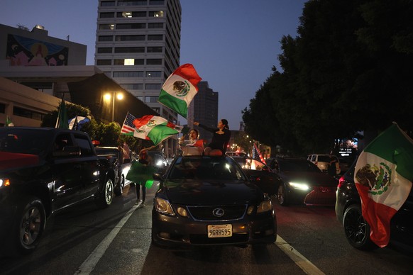 epa12167402 Protestors wave Mexican flags during protests sparked by immigration raids in Los Angeles, California, USA, 09 June 2025. US President Donald Trump has deployed 2,000 National Guard troops ...