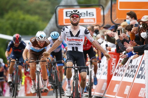 epa08708899 Swiss rider Marc Hirschi (C) of Team Sunweb celebrates while crossing the finish line to win the 84th edition of the Fleche Wallonne one day cycling race over 202km from Herve to Huy, Belg ...