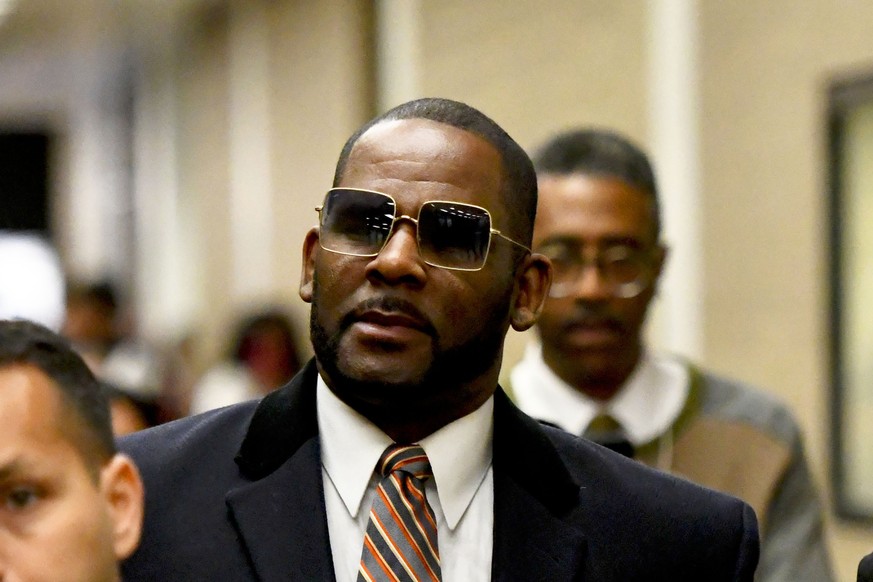 FILE - Musician R. Kelly, center, leaves the Daley Center after a hearing in his child support case on May 8, 2019, in Chicago. Closing arguments are scheduled Monday, Sept. 12, 2022 for R. Kelly and  ...