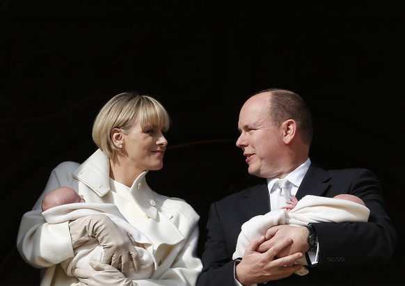 Princess Charlene and Prince Albert appear on a palace balcony, each holding a newborn baby swaddled in white in Monaco, Wednesday, Jan. 7, 2015. The hereditary heir Prince Jacques and his older siste ...