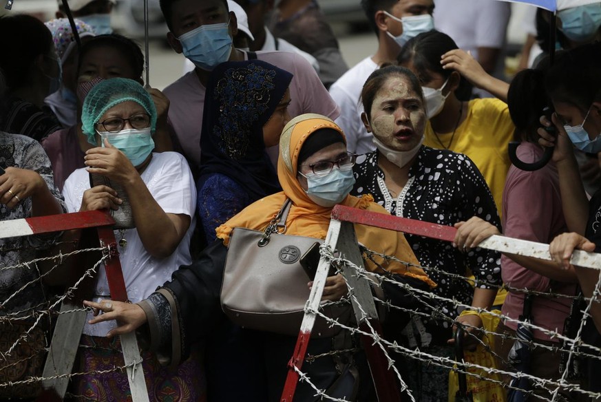 epa09312585 People wait behind barricades for their relatives to be released outside the main entrance of Insein prison compound in Yangon, Myanmar, 30 June 2021. The prison authority confirmed the up ...