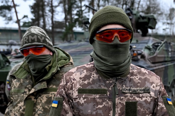 epa10480254 Soldiers of Ukraine army stand in front of a German Marder tank during a visit by German Defence Minister Boris Pistorius (not pictured) to military training area in Munster, Germany, 20 F ...