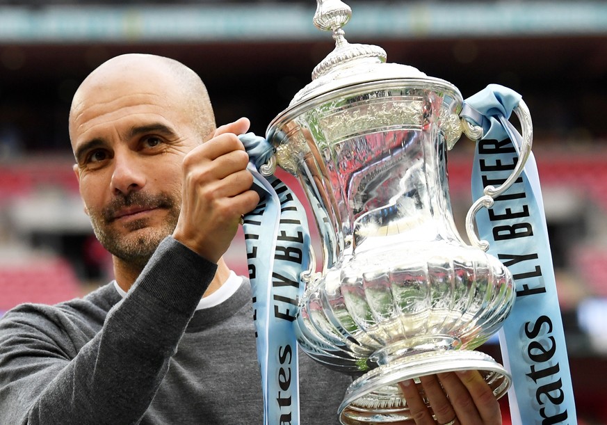 epa12983449 (FILE) - Manchester City manager Pep Guardiola poses with the trophy after the English FA Cup final between Manchester City and Watford at Wembley Stadium in London, Britain, 18 May 2019 ( ...
