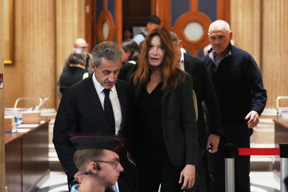 Former French President Nicolas Sarkozy and his wife Carla Bruni-Sarkozy leave the appeals courthouse in Paris, France, Tuesday, April 7, 2026, during his trial appealing a conviction involving illega ...