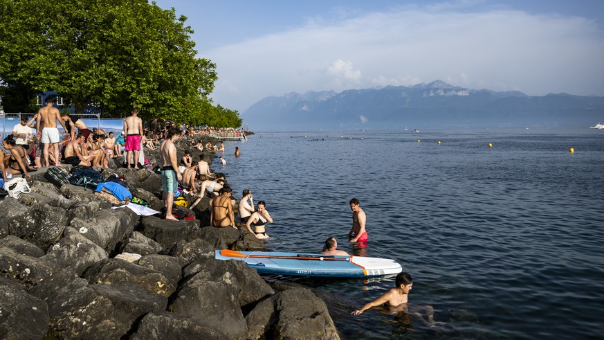Des personnes profitent du soleil et de la chaleur a cote du bar "La Jetee de la Compagnie" le vendredi 13 juin 2025 a Bellerive au bord du lac Leman a Lausanne. (KEYSTONE/Jean-Christophe Bo ...