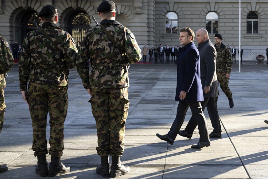French President Emmanuel Macron, left, and Switzerland President Alain Berset, right, inspect the guard of honour of the Swiss army, on the Federal square in front of the Federal Palace, the Swiss Pa ...