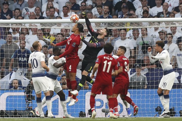 Liverpool&#039;s Virgil Van Dijk, top left, jumps with Tottenham goalkeeper Hugo Lloris during the Champions League final soccer match between Tottenham Hotspur and Liverpool at the Wanda Metropolitan ...