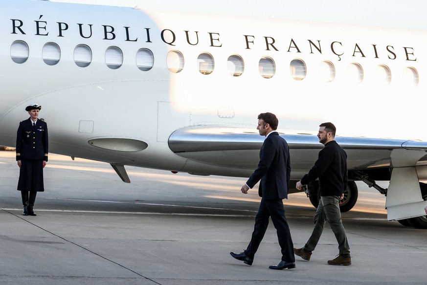 epa10456112 French President Emmanuel Macron (C) walks next to Ukraine&#039;s President Volodymyr Zelensky (R) before heading to Brussels, in Military Airport Villacoublay, in Velizy-Villacoublay, Sou ...