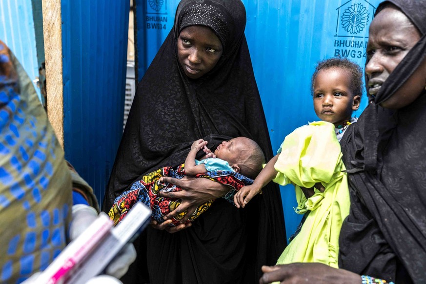 Une réfugiée (au centre) tient son nouveau-né dans ses bras tandis qu'elle écoute un agent de santé dans un centre médical de Médecins Sans Frontières (MSF) à Douéinkara, près de la frontière ent ...