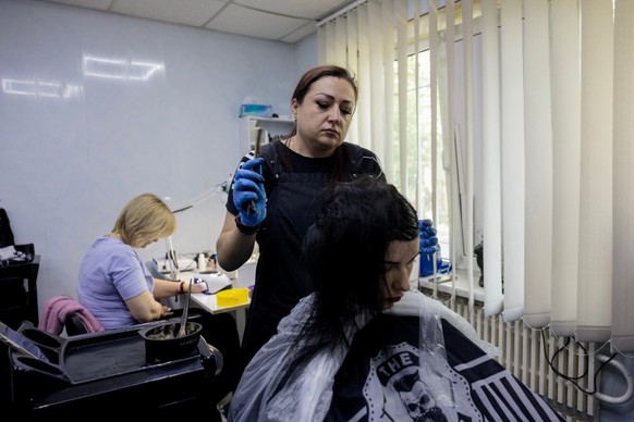 Hairdresser Yevgenia Gotavtsova (C) dyes hair for a client in a beauty salon in Druzhkivka, eastern Donetsk region, on May 5, 2025, amid the Russian invasion of Ukraine. For Ukrainians near the front, ...