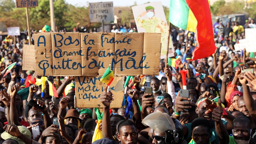 epa09728422 A person holds a sign that reads &#039;Down with France, the French army, leave Mali&#039; as people gather for a demonstration called by Yerewolo Ton movement at the Tour d&#039;Afrique m ...