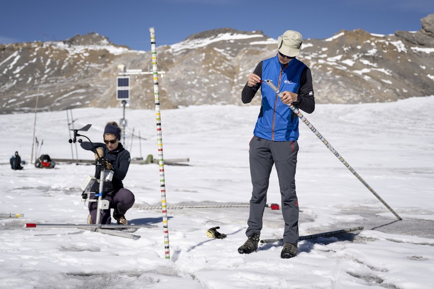Matthias Huss, glaciologue a l&#039;Ecole polytechnique de Zurich (ETH Zurich), a gauche, fait des mesures du bilan de masse pour documenter la fonte du glacier de la Plaine Morte, se situant dans le  ...