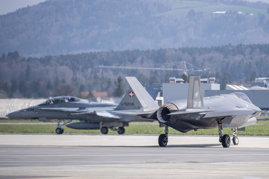 Ein Kampfflugzeug des Typ F-35A, rechts, und ein FA-18, links, der Schweizer Armee starten auf dem Flugplatz Emmen, anlaesslich der &quot;Armeebotschaft 2022&quot; der Schweizer Luftwaffe zum Kampfflu ...