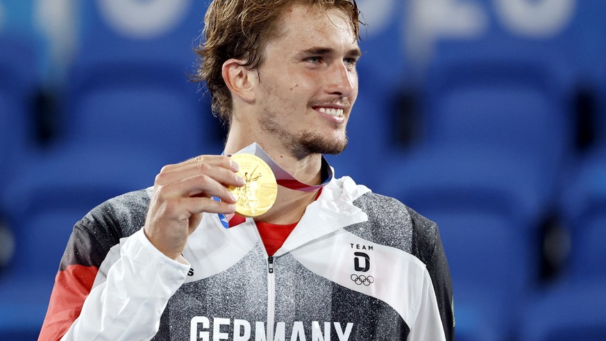 epa09384916 Gold medalist Alexandar Zverev of Germany celebrates on the podium after winning the Men&#039;s Single gold medal match during the Tennis events of the Tokyo 2020 Olympic Games at the Aria ...