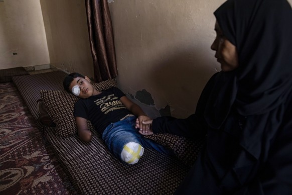 epa11616378 Palestinian teen Wahid Al-Ghalban, 13, rests on a mattress while holding his mother&#039;s hand in Khan Yunis, southern Gaza Strip, 19 September 2024 (issued 20 September 2024). Wahid, an  ...